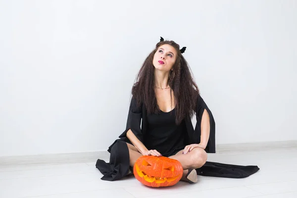 Halloween et concept de mascarade - Belle jeune femme posant avec citrouille Jack-o-lanterne . — Photo