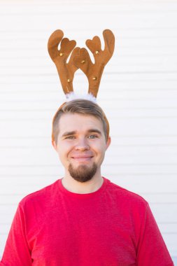 Tatil ve Noel kavramı - geyikler boynuzları beyaz arka plan üzerinde mutlu delikanlı