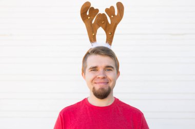 Tatil ve Noel kavramı - geyikler boynuzları beyaz arka plan üzerinde mutlu delikanlı