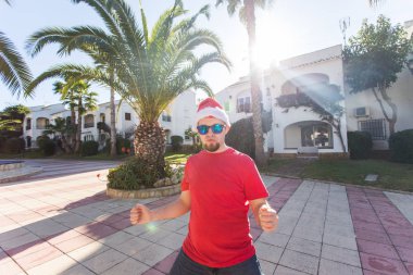 Tatil ve insanlar kavramı - Santa Claus şapka dans genç çekici adam