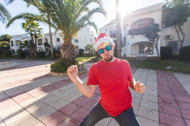 Tatil ve insanlar kavramı - Santa Claus şapka dans genç çekici adam