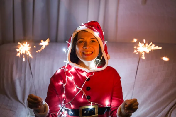 Noël, vacances et concept de personnes - jeune femme heureuse riant en costume de Noël avec des lumières sur le fond blanc — Photo