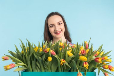 Büyük bir demet lale mavi zemin üzerine beyaz genç kadın