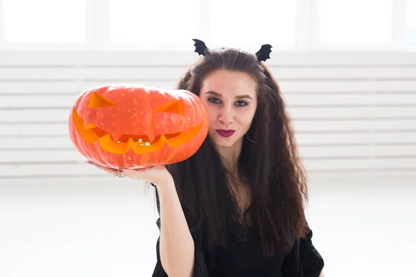 Glücklich gotische junge Frau im Hexen-Halloween-Kostüm lächelnd über weißem Zimmerhintergrund — Stockfoto