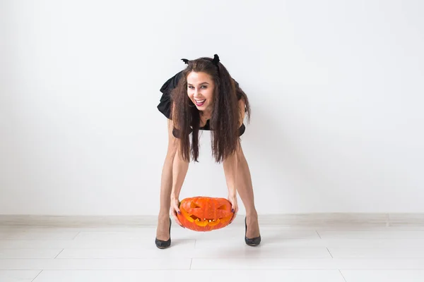 Concepto de Halloween - Bruja feliz con calabaza Jack-o-linterna sobre fondo claro con espacio de copia —  Fotos de Stock