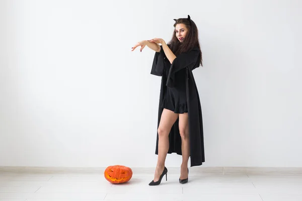Halloween i święta koncepcja - czarownica kobieta z dyni Jack Olantern na jasnym tle z miejsca kopii — Zdjęcie stockowe