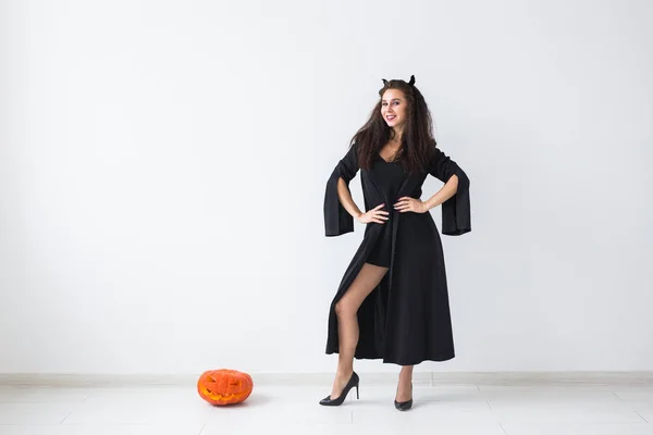 Halloween e le vacanze concetto - Strega donna con Jack OLantern zucca su sfondo chiaro con spazio copia — Foto Stock