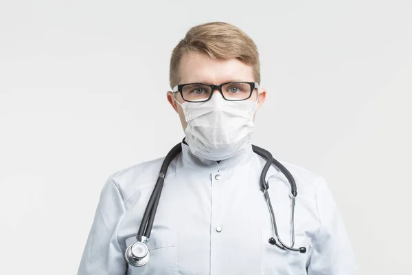 Santé et médecine - médecin portant le stéthoscope et le masque blanc sur fond blanc — Photo