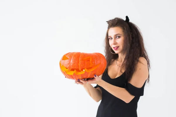 Porträt einer stilvollen brünetten Frau mit Halloween-Kürbis mit Kopierraum lizenzfreie Stockfotos