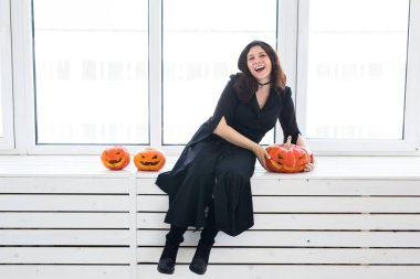 Mutlu Gotik genç kadın cadı halloween kılık beyaz Oda arka plan üzerinde gülümseyen