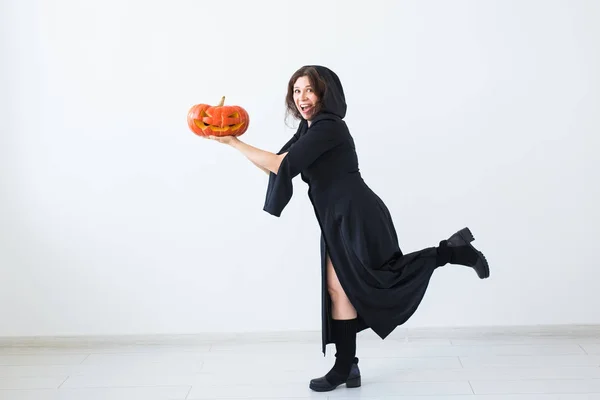 Portrait d'une femme brune élégante avec citrouille halloween sur fond clair — Photo