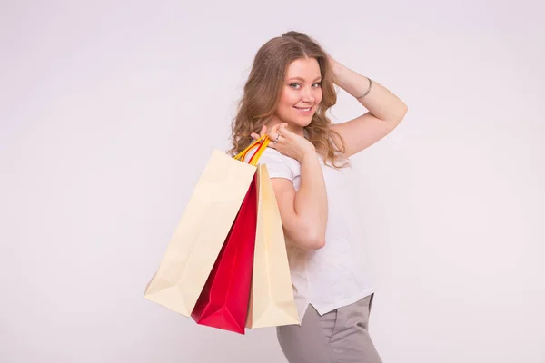 Mujer rubia europea feliz sosteniendo bolsas de compras sobre fondo blanco con espacio de copia — Foto de Stock