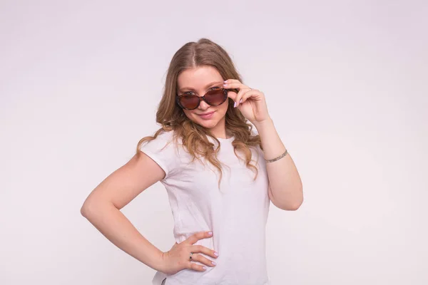 Porträt einer rätselhaften schönen weißen Mädchen Fixierung Haar trägt Sonnenbrille auf weißem Hintergrund — Stockfoto