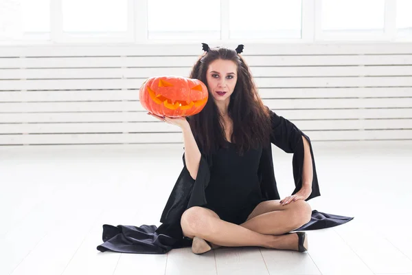Halloween und Maskerade Konzept - schöne junge Frau posiert mit Kürbis Jack-o-Laterne. — Stockfoto