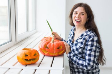 Halloween kabak kesim işlemi. Genç kadın Jack-o-lantern yapma.