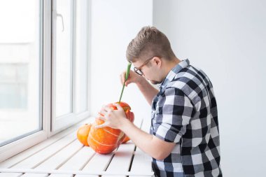 Cadılar bayramı fenerini hazırlamak için balkabağını oyuyor..