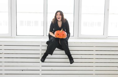 Heyecanlı mutlu genç kadın içinde lightroom içinde oyulmuş kabak ile poz halloween kılık