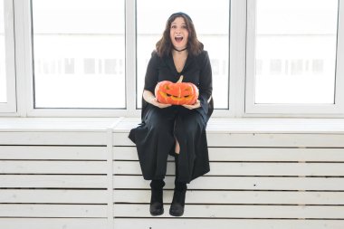 Heyecanlı mutlu genç kadın içinde lightroom içinde oyulmuş kabak ile poz halloween kılık