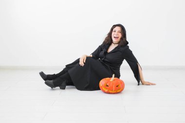 Mutlu Gotik genç kadın cadı halloween kılık beyaz Oda arka plan üzerinde gülümseyen