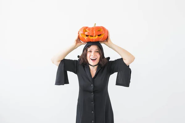 Feliz joven gótica disfrazada de bruja halloween sonriendo sobre el fondo de la habitación blanca — Foto de Stock