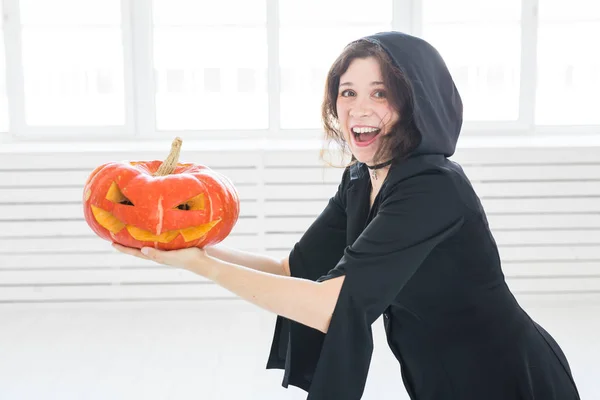 Heyecanlı mutlu genç kadın içinde lightroom içinde oyulmuş kabak ile poz halloween kılık — Stok fotoğraf