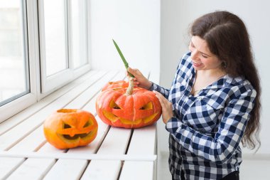 Cadılar bayramı fenerini hazırlamak için balkabağını oyuyor..
