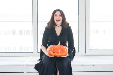 Heyecanlı mutlu genç kadın içinde lightroom içinde oyulmuş kabak ile poz halloween kılık