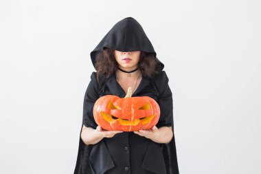 Gotik genç kadın cadı beyaz Oda arka plan üzerinde Jack-o-lantern ile halloween kılık