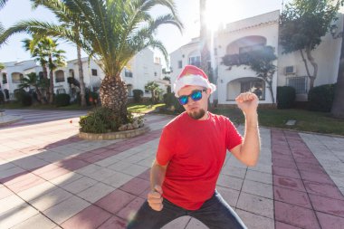 Tatil ve insanlar kavramı - Santa Claus şapka dans genç çekici adam