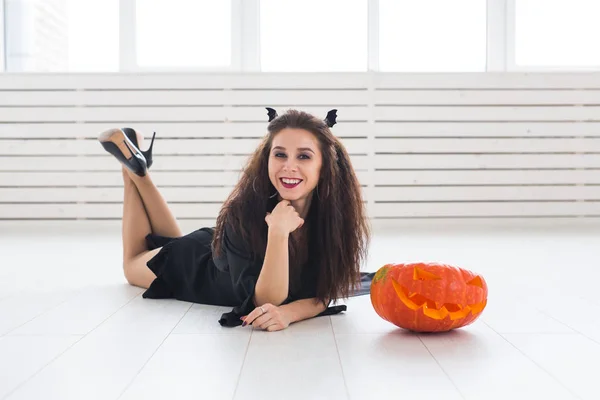 Halloween y el concepto de mascarada - Hermosa joven posando con calabaza Jack-o-linterna . — Foto de Stock