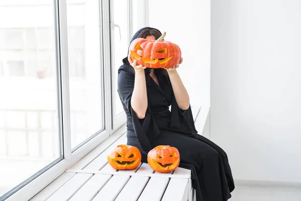 Halloween en maskerade concept - mooie jonge vrouw met pompoen Jack-o-lantaarn. — Stockfoto