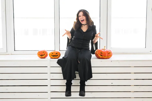 Conceito de Halloween - Bruxa feliz com abóbora Jack-o-lanterna no fundo de luz — Fotografia de Stock