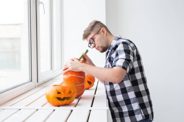 Cadılar bayramı fenerini hazırlamak için balkabağını oyuyor..