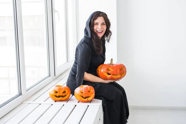 Feliz gótico jovem mulher no bruxa halloween traje sorrindo sobre branco quarto fundo — Fotografia de Stock