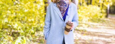 Sonbahar, içecekler ve insanlar kavramı - kadının elinde sıcak bir içecek fincan