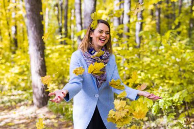 Sezon, Doğa ve insan kavramı - genç kadın ile sonbahar oynarken parkta bırakır.
