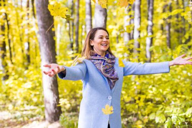 Sonbahar, eğlenceli ve zevk kavramı - yaprakları buket atma Genç güzel kadın