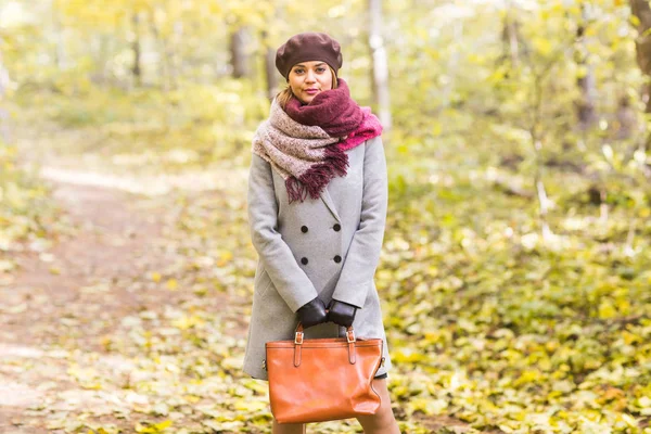 Outono, natureza, conceito de pessoas - bela jovem com um casaco cinza e uma boina em pé no parque . — Fotografia de Stock