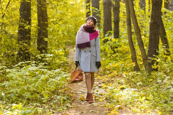 Conceito de outono, temporada e pessoas mulher de casaco com saco marrom em pé no parque de outono — Fotografia de Stock