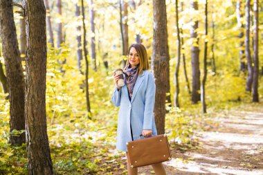 Sonbahar, Doğa, insanlar kavramı - mavi ceket daimi bir fincan kahve ile parkta genç esmer kadın
