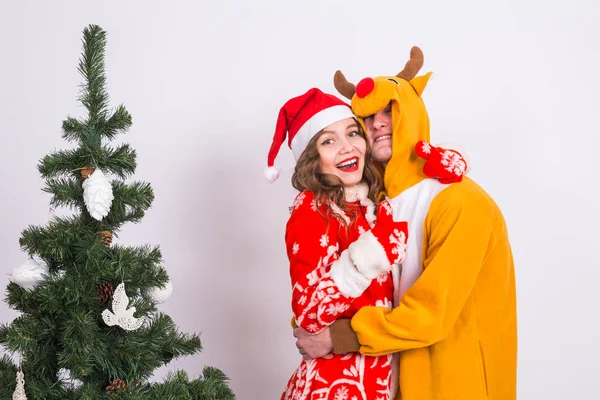 Vacances, Noël et les émotions concept - beau couple en costumes de Noël étreignant sur fond blanc — Photo