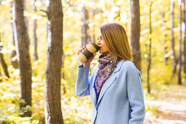 Autumn, drinks and people concept - Woman holding cup of hot drink