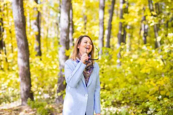 Natuur, seizoen en mensen concept - jonge vrouw met een zonnebril in de herfst park — Stockfoto