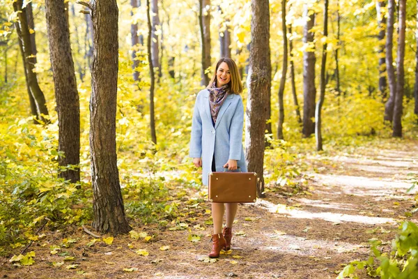 Conceito de queda, estação e pessoas - mulher no parque de outono passeando com mala — Fotografia de Stock