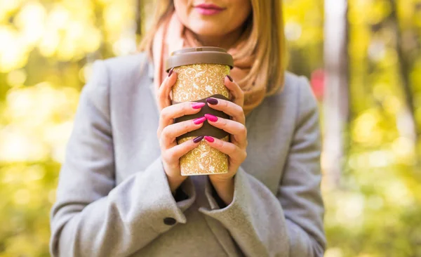 Conceito de outono, natureza e pessoas - Close up de mulher de casaco cinza segurando uma xícara de café — Fotografia de Stock