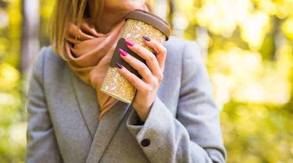 Autumn, drink and coffee concept - Close up of woman in grey coat with cup of coffee