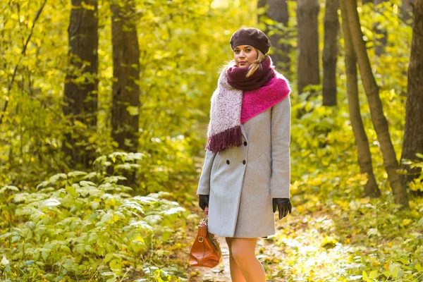 Herfst, de natuur en de mensen concept - mooie jongedame in een grijze jas reputatie in herfst park — Stockfoto