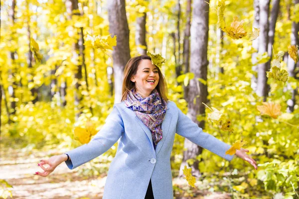 Herfst, plezier en genot concept - mooie jongedame gooien boeket van bladeren — Stockfoto