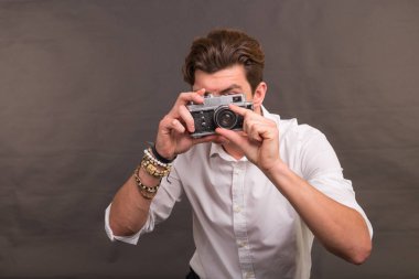 İnsanlar, fotoğrafçı ve vintage kavramı - vintage bir kamera kahverengi zemin üzerinde tutarak onun fotoğraf için ilginç bir konu için arayan