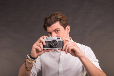 Teknoloji, fotoğraf ve hobi kavramı - retro kamera, sana bir fotoğraf gri arka plan üzerinde çekici adamla